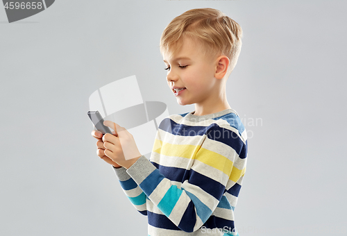 Image of little boy in striped pullover using smartphone