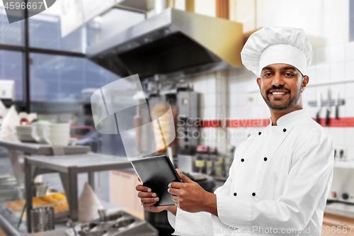 Image of male indian chef with tablet pc at kebab shop