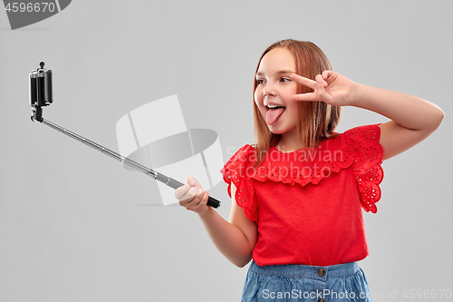 Image of girl taking picture by smartphone on selfie stick