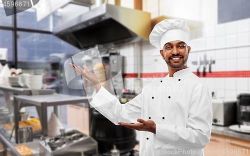 Image of happy male indian chef in toque at kebab shop