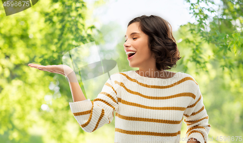 Image of woman with empty hand over natural background