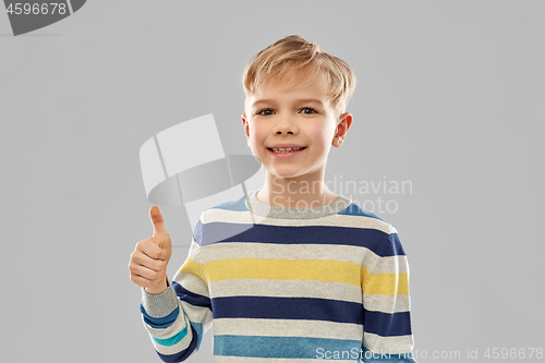 Image of smiling boy in striped pullover showing thumbs up