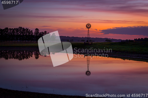 Image of Sunrise over dam with wind mill in rural Australia