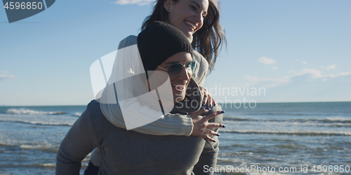 Image of couple having fun at beach during autumn