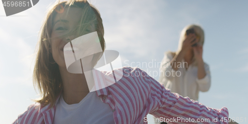 Image of Two girl friends having fun photographing each other on vecation