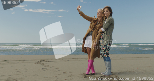 Image of Girls having time and taking selfie on a beach