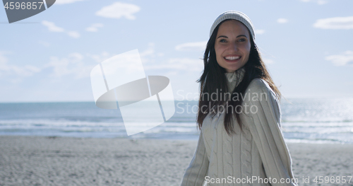 Image of Girl In Autumn Clothes Smiling on beach