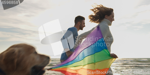 Image of Happy couple having fun with kite on beach