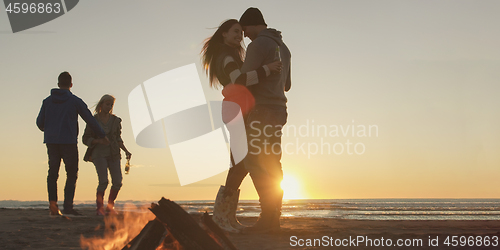 Image of Friends having fun at beach on autumn day