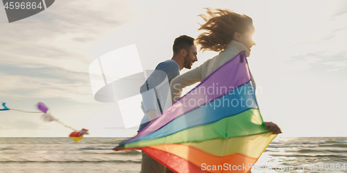 Image of Happy couple having fun with kite on beach