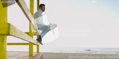 Image of man drinking beer at the beach