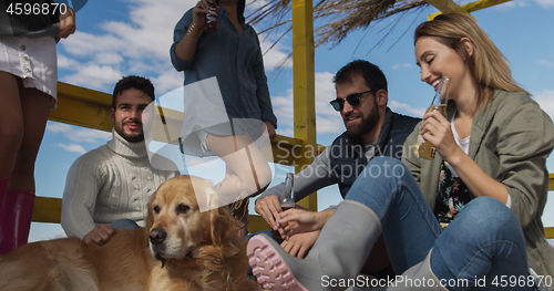 Image of Group of friends having fun on autumn day at beach