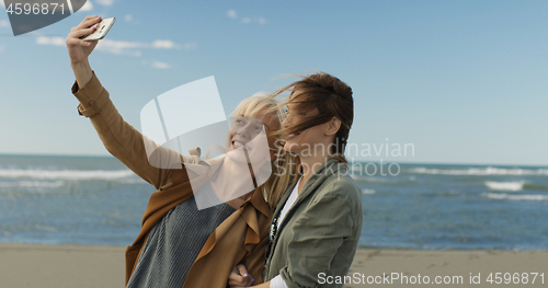 Image of Girls having time and taking selfie on a beach