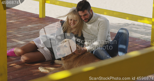 Image of Couple with dog enjoying time on beach