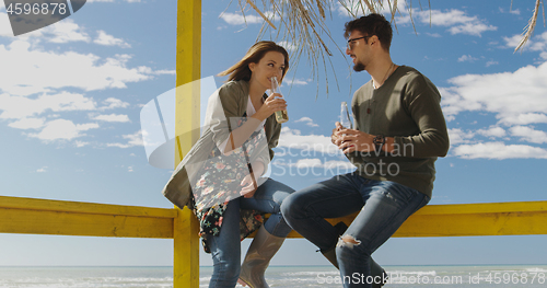 Image of Group of friends having fun on autumn day at beach