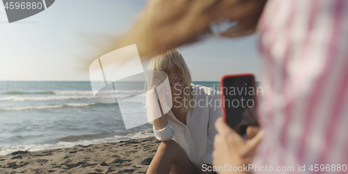 Image of Two girl friends having fun photographing each other on vecation
