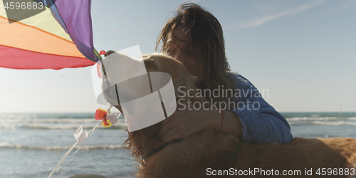 Image of Woman holding kite at beach on autumn day