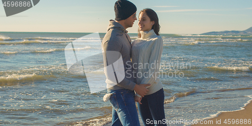Image of Couple having fun on beautiful autumn day at beach
