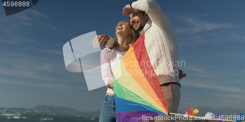 Image of Happy couple having fun with kite on beach