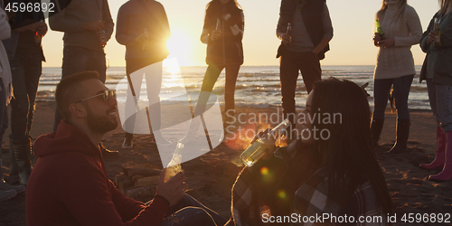 Image of Friends having fun at beach on autumn day