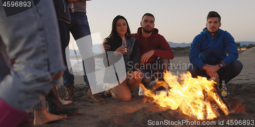 Image of Friends having fun at beach on autumn day