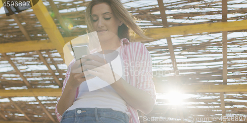 Image of Smartphone Woman Texting On Cell Phone At Beach