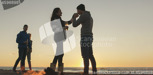 Image of Friends having fun at beach on autumn day