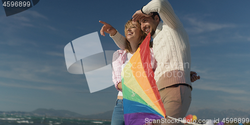 Image of Happy couple having fun with kite on beach