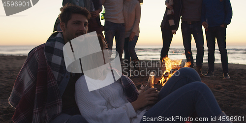 Image of Friends having fun at beach on autumn day