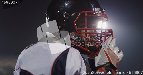 Image of American Football Player Putting On Helmet on large stadium with