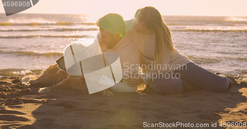 Image of Couple with dog enjoying time on beach