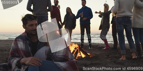 Image of Friends having fun at beach on autumn day