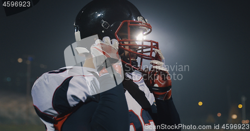 Image of American Football Player Putting On Helmet on large stadium with