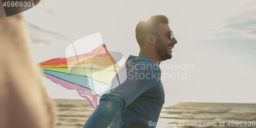 Image of Happy couple having fun with kite on beach