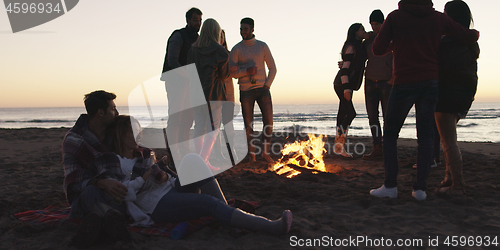 Image of Friends having fun at beach on autumn day