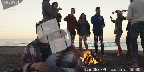 Image of Friends having fun at beach on autumn day