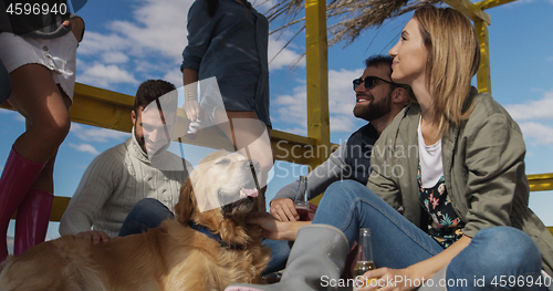 Image of Group of friends having fun on autumn day at beach