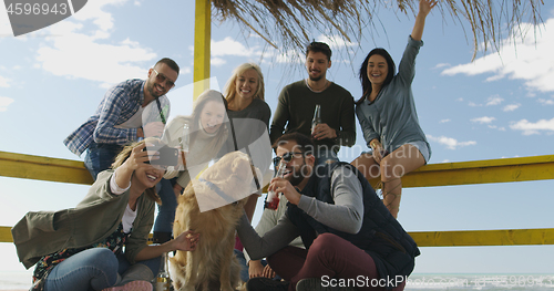 Image of Group of friends having fun on autumn day at beach