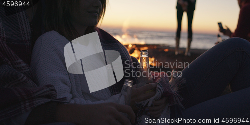 Image of Friends having fun at beach on autumn day