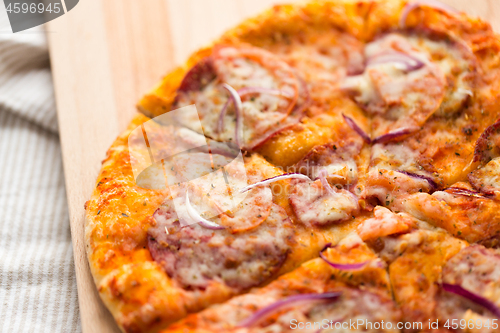 Image of close up of homemade pizza on wooden table