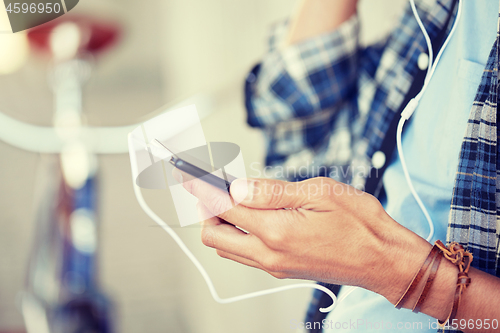 Image of man with earphones and smartphone listening music