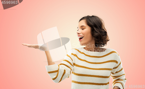 Image of smiling young woman holding empty palm