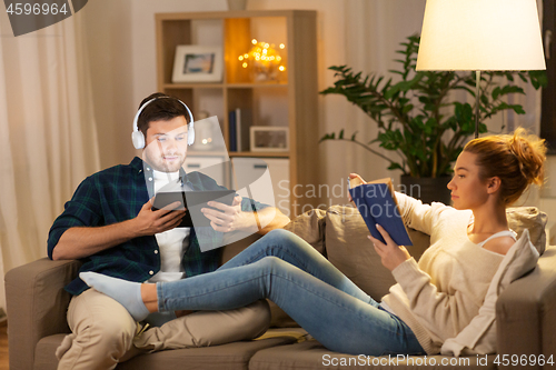 Image of couple with tablet computer and book at home