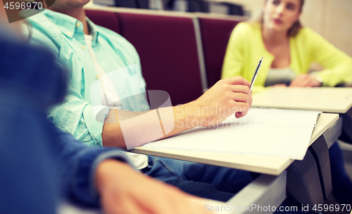 Image of group of students with notebooks at lecture hall