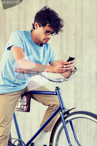 Image of man with smartphone and fixed gear bike on street