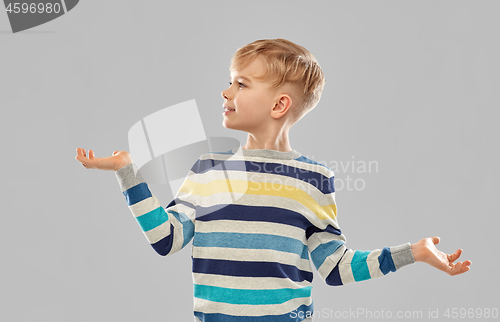 Image of smiling boy holding something on empty hands