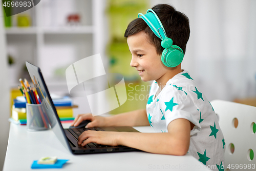 Image of boy in headphones playing video game on laptop