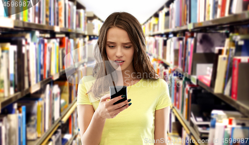 Image of teenage student girl using smartphone at library