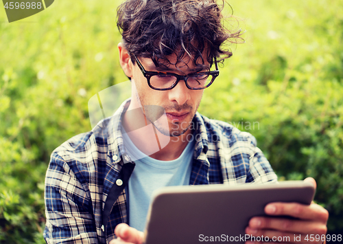 Image of man in glasses with tablet pc computer outdoors