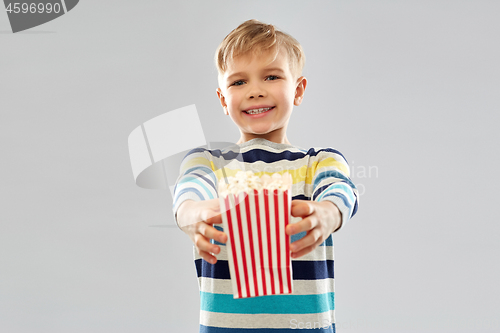 Image of little boy holding paper bucket with popcorn